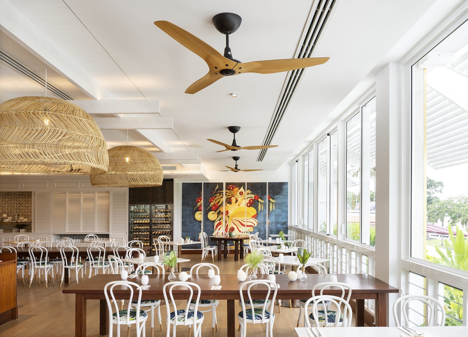 Ceiling fans with wood finish installed in a stylish commercial dining space