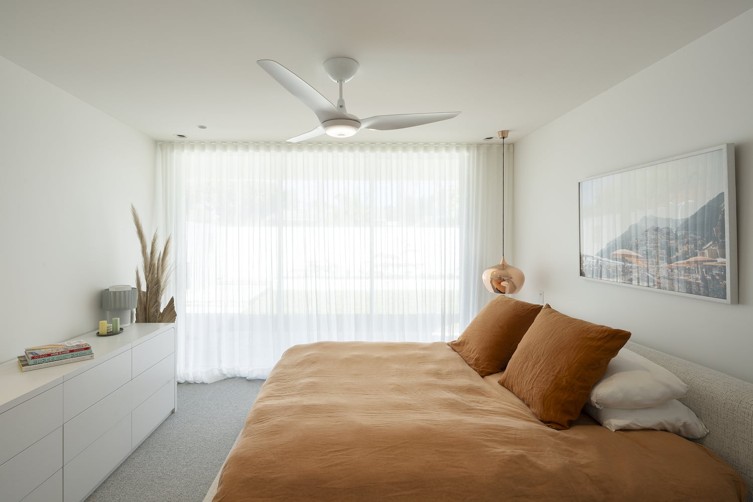 Minimalist bedroom with a white residential fan