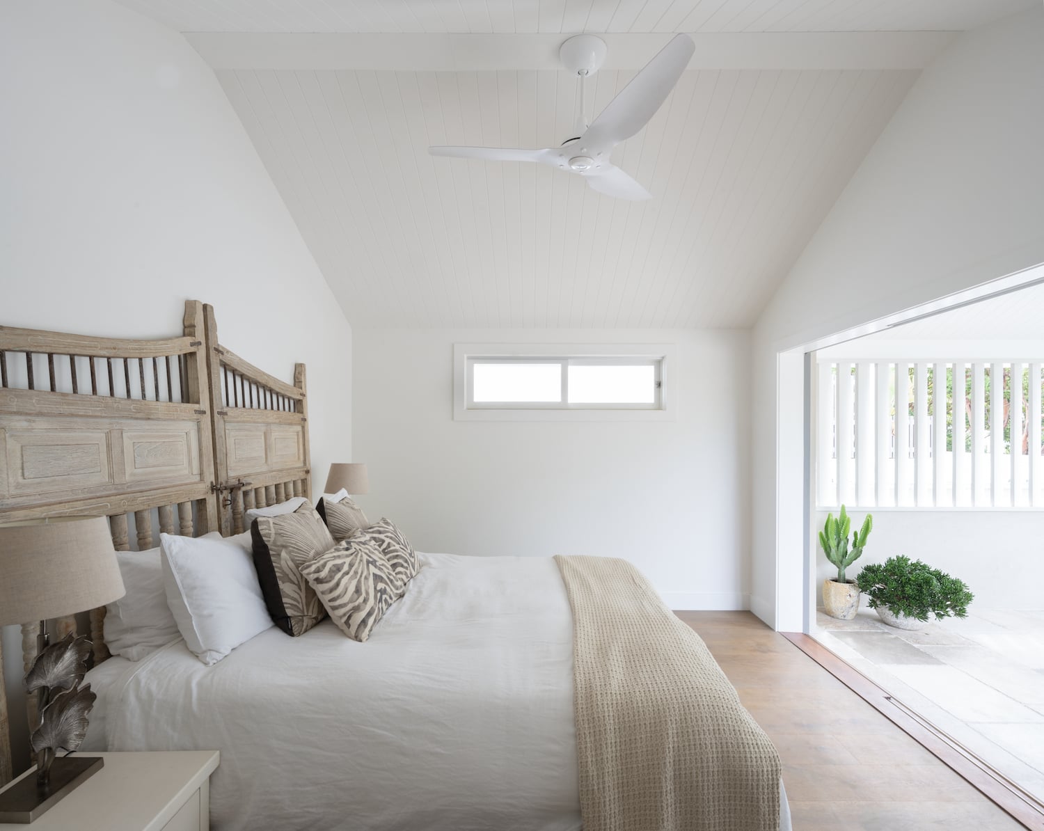 Bright bedroom with a white residential fan