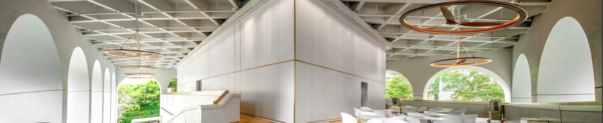 Indoor space with ceiling fans and arched windows