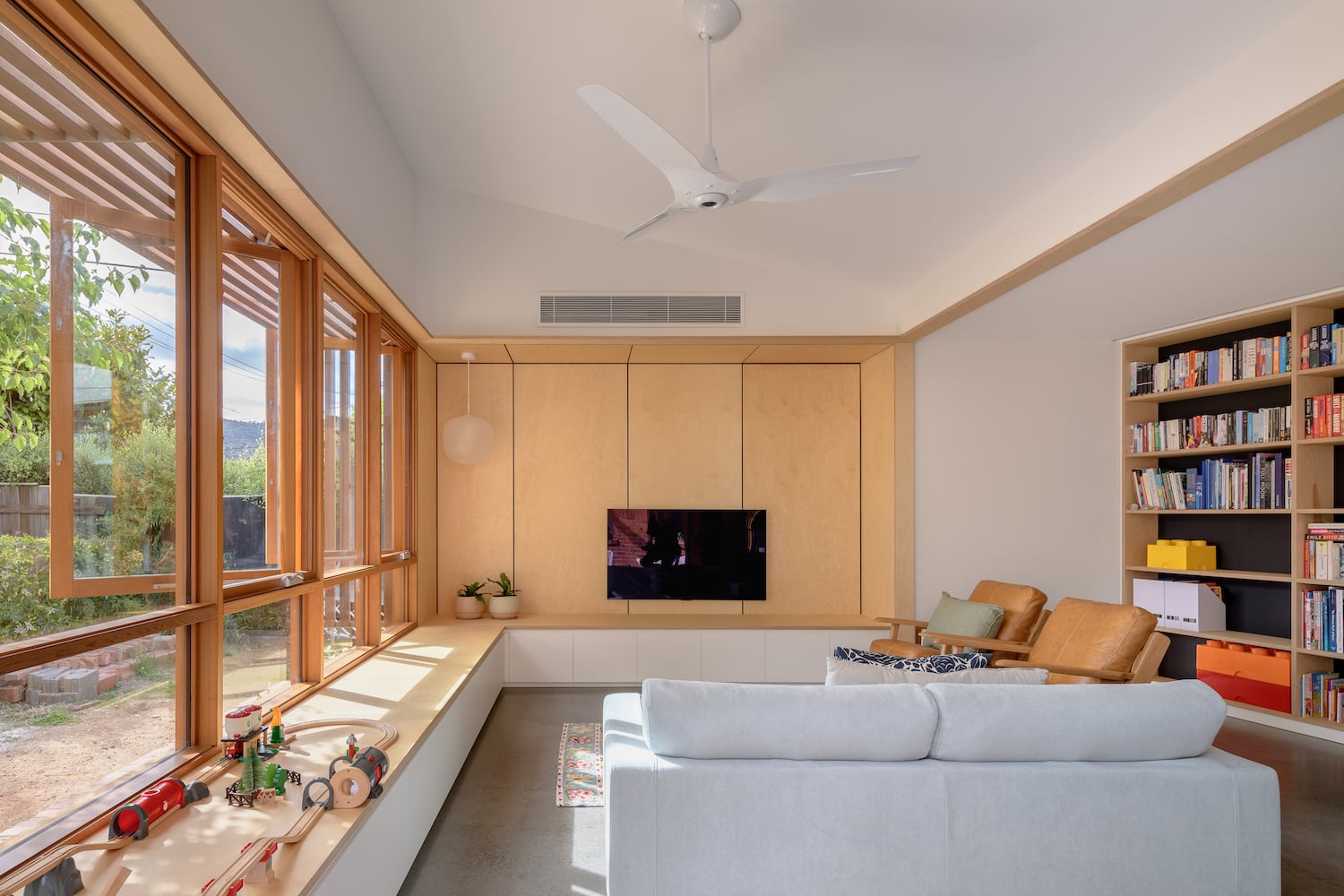 White ceiling fan installed in a bright residential living room with wood accents